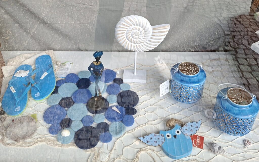 Schaufenster Weltladen mit vielen sommerlich blauen Artikeln